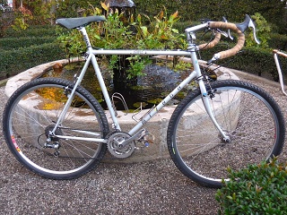 A Taiwan made early 1990s soccer dad hybrid turned into a proto gravel bike in around 2012; sold in 2026. Lugged frame; unicrown fork; big bang for the low bucks. 